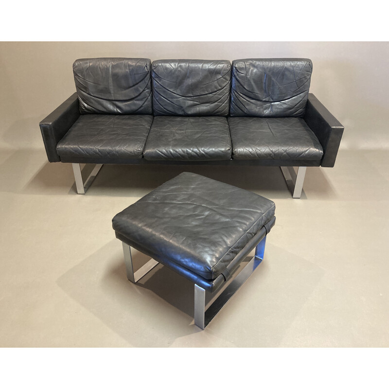 Vintage black leather sofa and its ottoman 1960