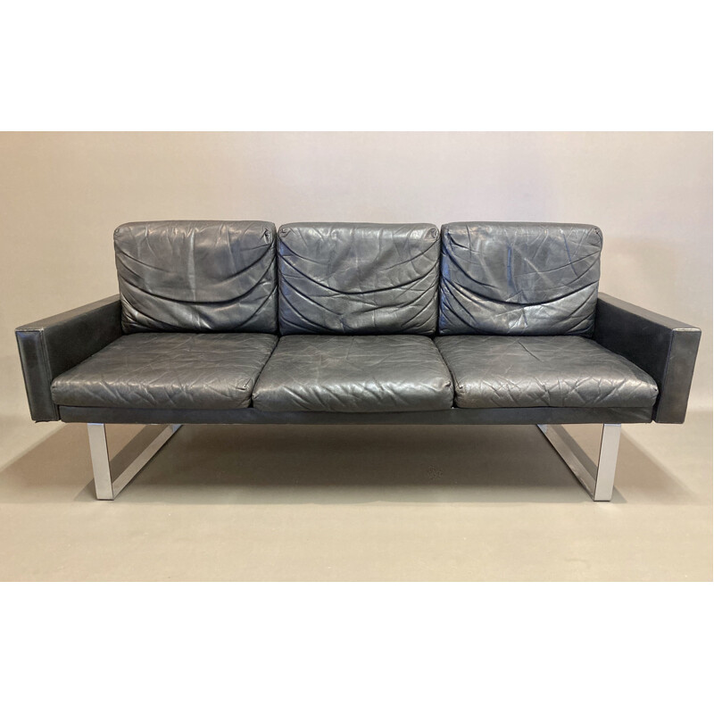Vintage black leather sofa and its ottoman 1960