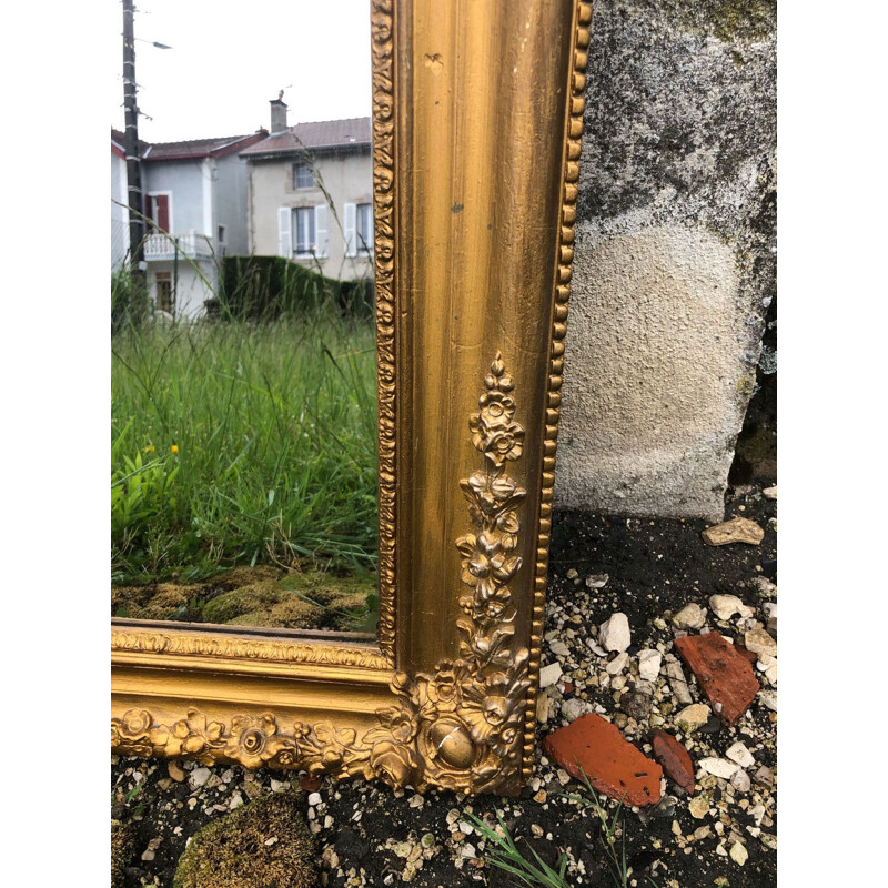 Vintage gold mirror tinted with mercury and carved with flowers around the edge