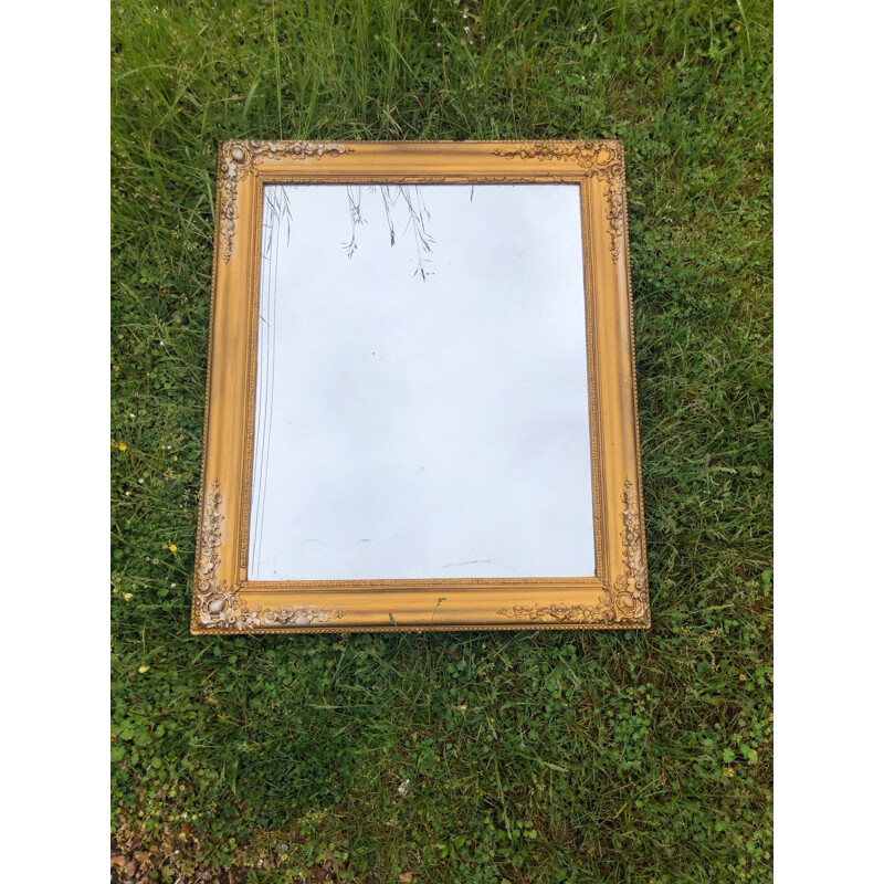 Vintage gold mirror tinted with mercury and carved with flowers around the edge