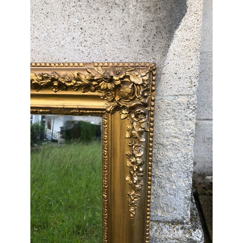 Vintage gold mirror tinted with mercury and carved with flowers around the edge