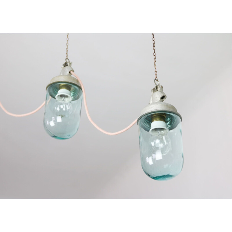 Paar vintage hanglampen in industrieel blauw glas en grijs metaal