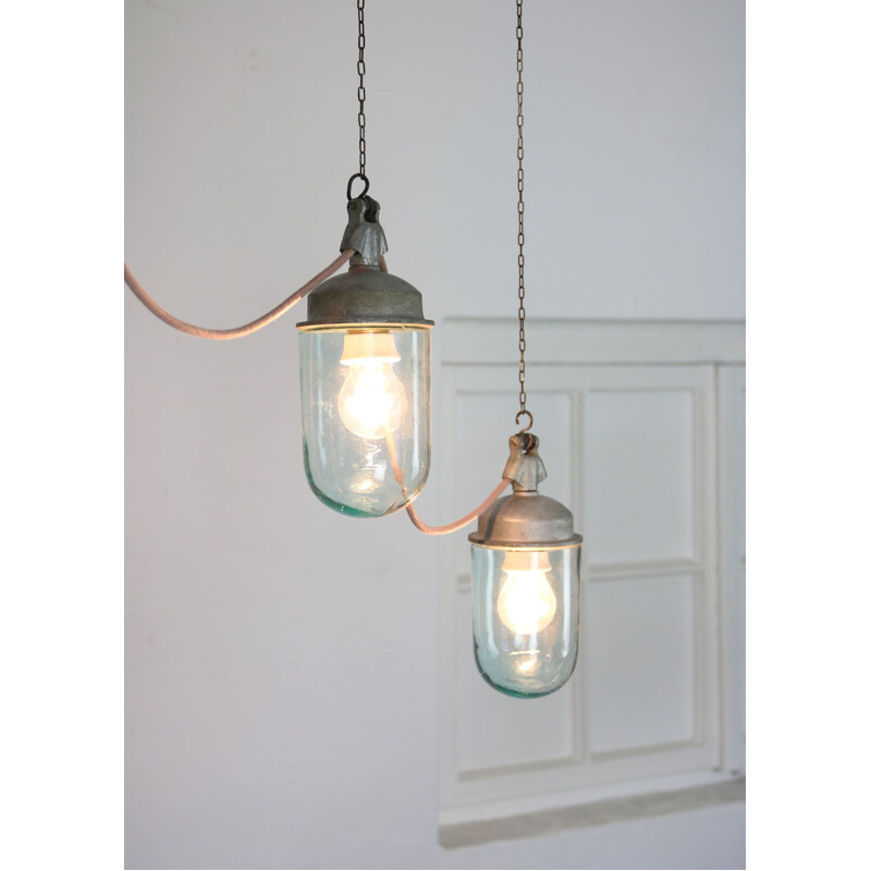 Paar vintage hanglampen in industrieel blauw glas en grijs metaal