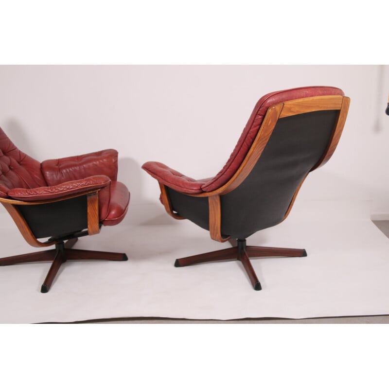 Pair of vintage leather swivel armchairs with wood accents and red leather upholstery 1960