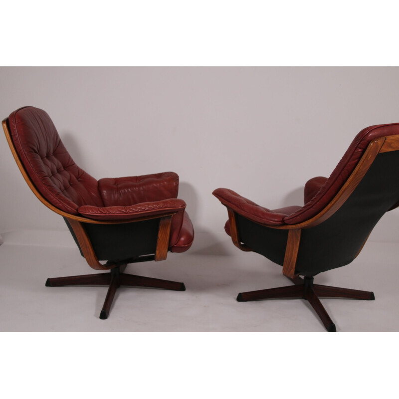 Pair of vintage leather swivel armchairs with wood accents and red leather upholstery 1960