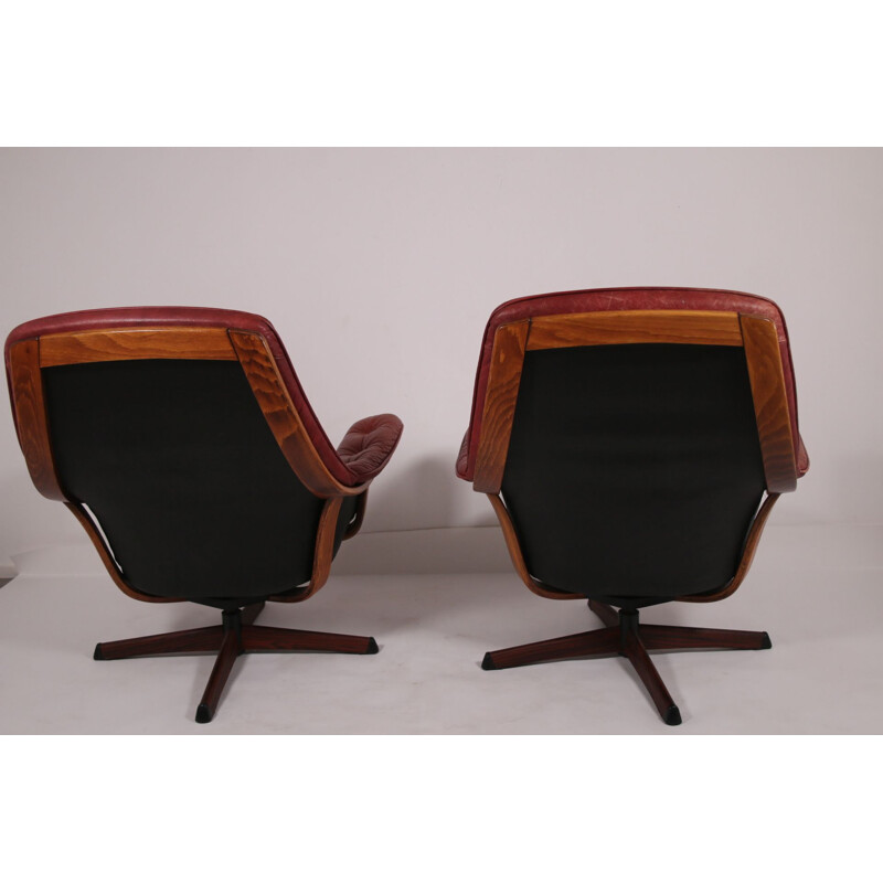 Pair of vintage leather swivel armchairs with wood accents and red leather upholstery 1960