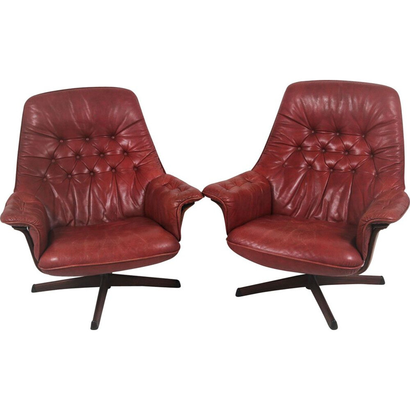 Pair of vintage leather swivel armchairs with wood accents and red leather upholstery 1960