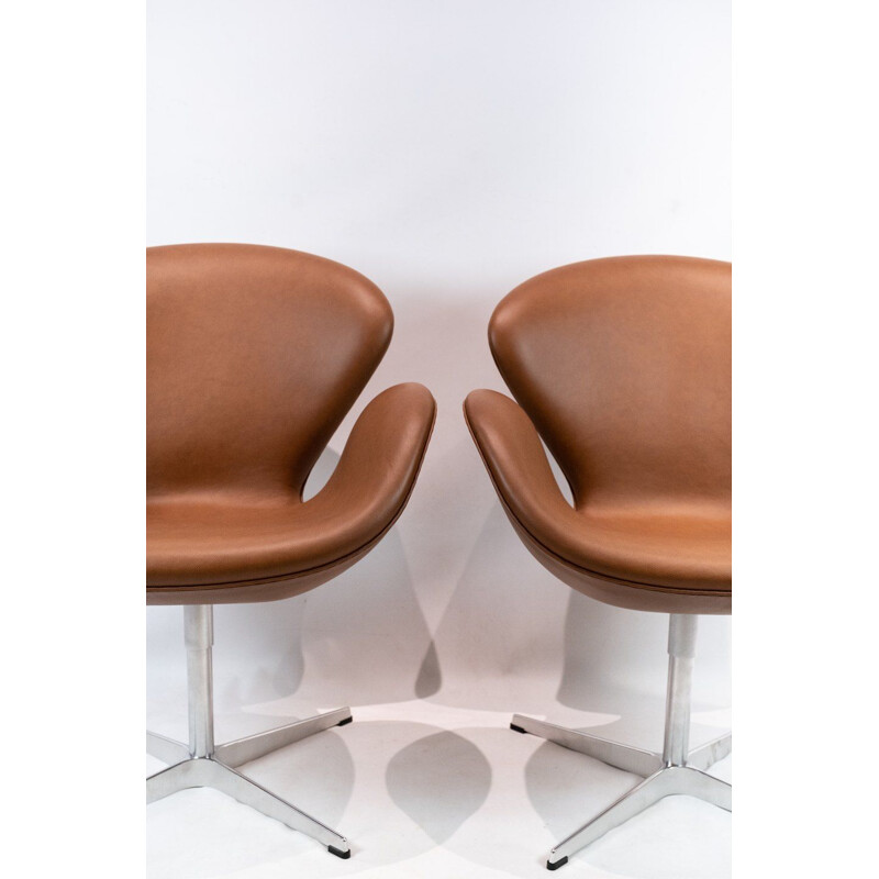 A pair of leather swan chairs, model 3320, Arne Jacobsen for Fritz Hansen. 