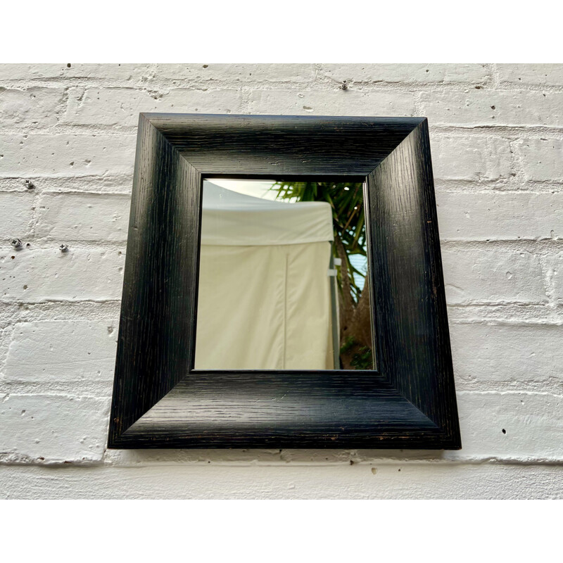 Vintage wall mirror with a thick black wooden frame 