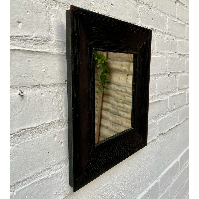 Vintage wall mirror with a thick black wooden frame 