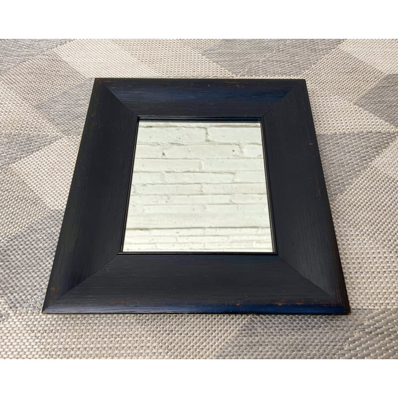 Vintage wall mirror with a thick black wooden frame 