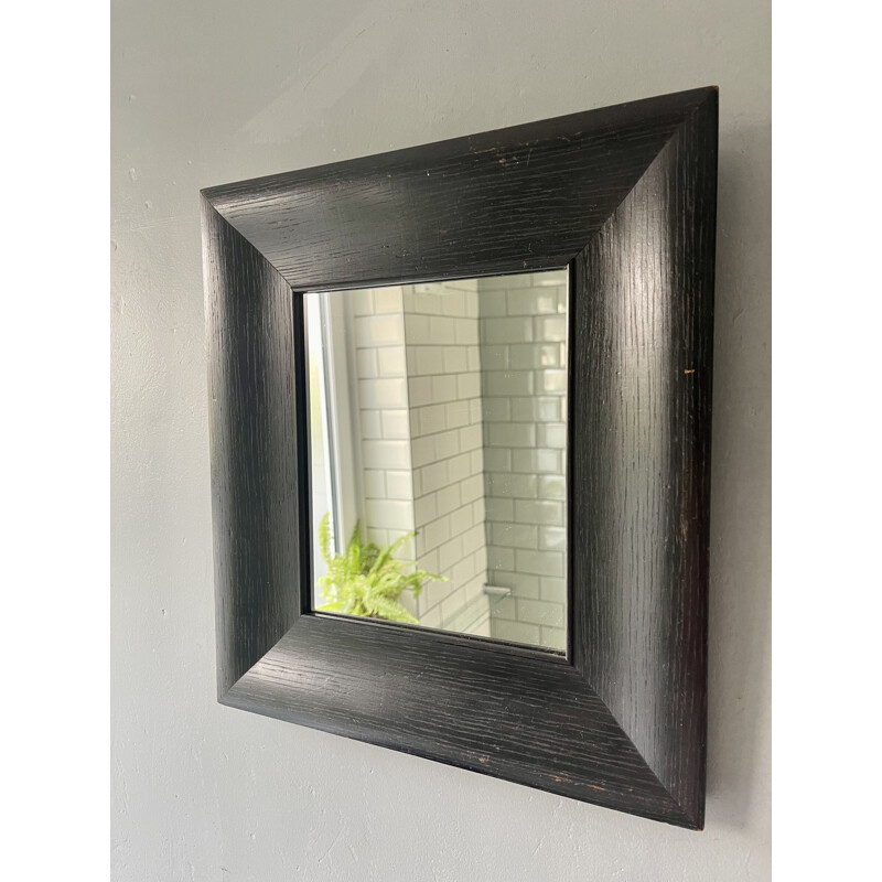 Vintage wall mirror with a thick black wooden frame 