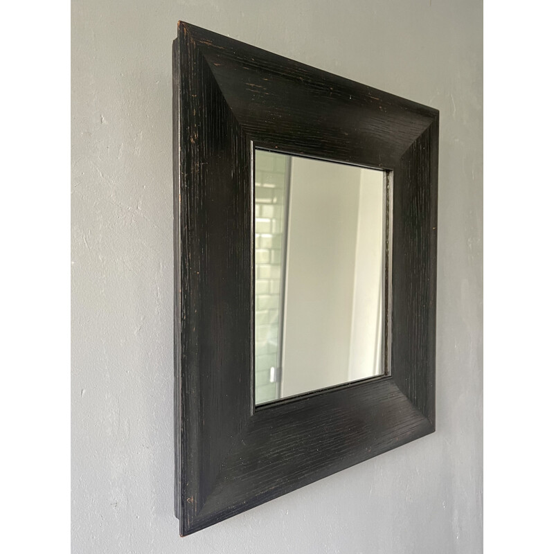 Vintage wall mirror with a thick black wooden frame 