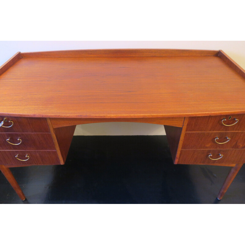 Vintage teak desk with curved shape raised edge and storage space Danish 1960s