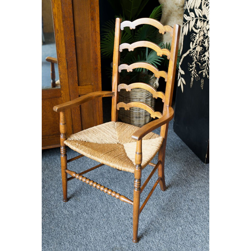 Silla vintage de roble macizo con respaldo de escalera y asiento de junco, Inglaterra 1920
