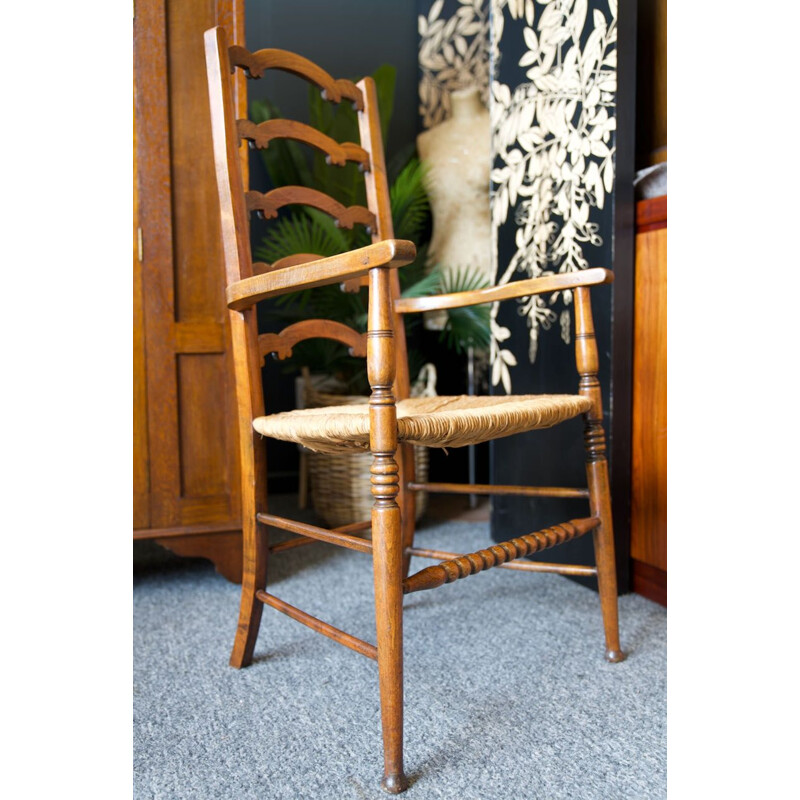 Silla vintage de roble macizo con respaldo de escalera y asiento de junco, Inglaterra 1920