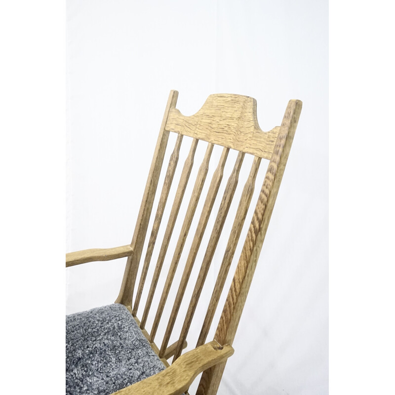Mid-century rocking chair in solid oakwood with lamb wool upholstery by Henning Kjærnulf