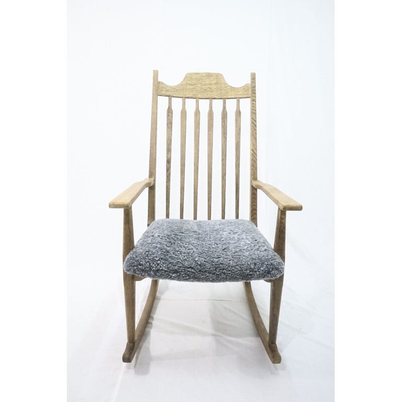 Mid-century rocking chair in solid oakwood with lamb wool upholstery by Henning Kjærnulf