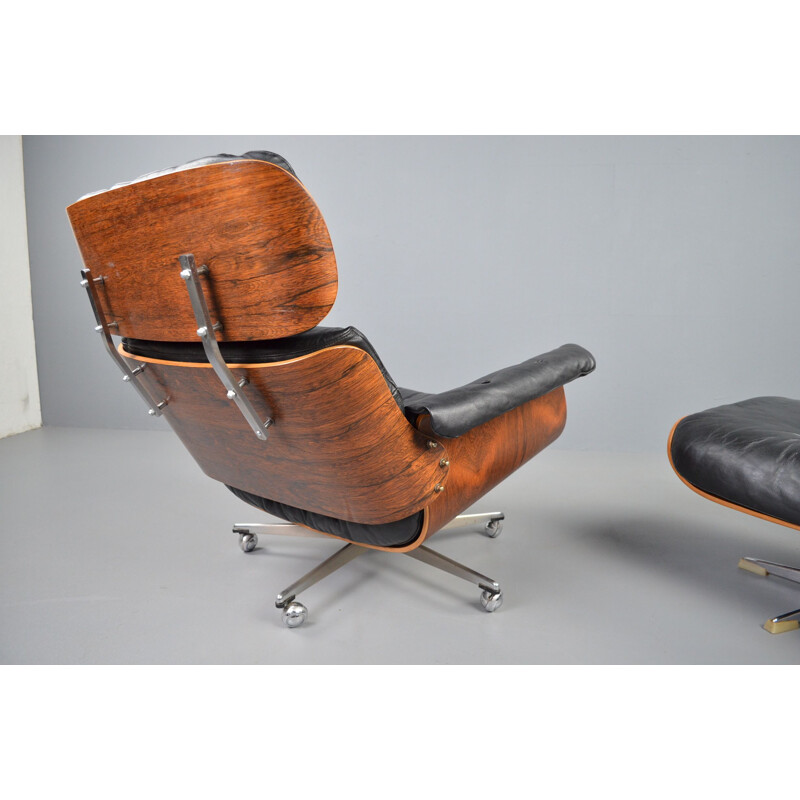 Vintage rosewood and black leather lounge chair with ottoman by Martin Stoll