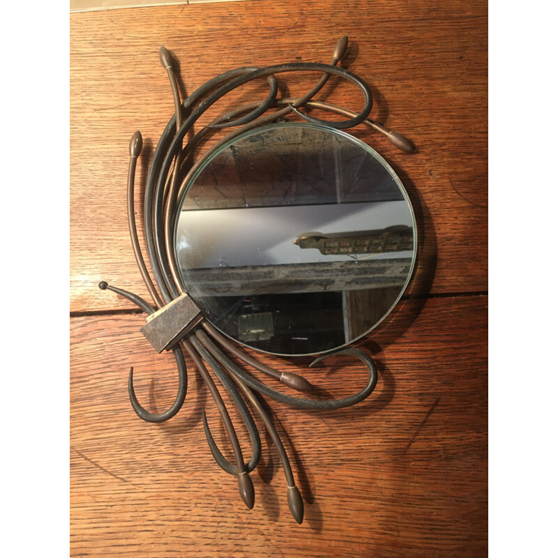 Specchio vintage rotondo circondato da piante in metallo