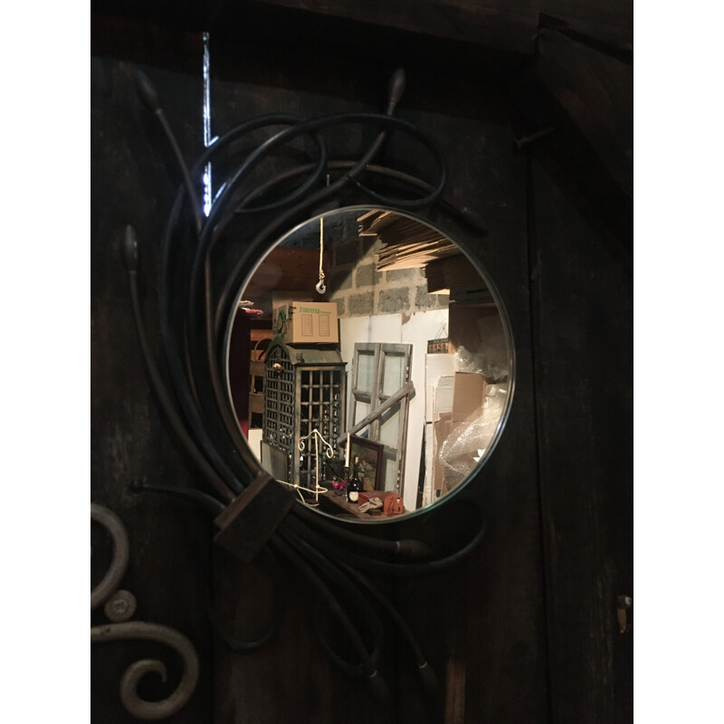 Round vintage mirror surrounded by metal plants