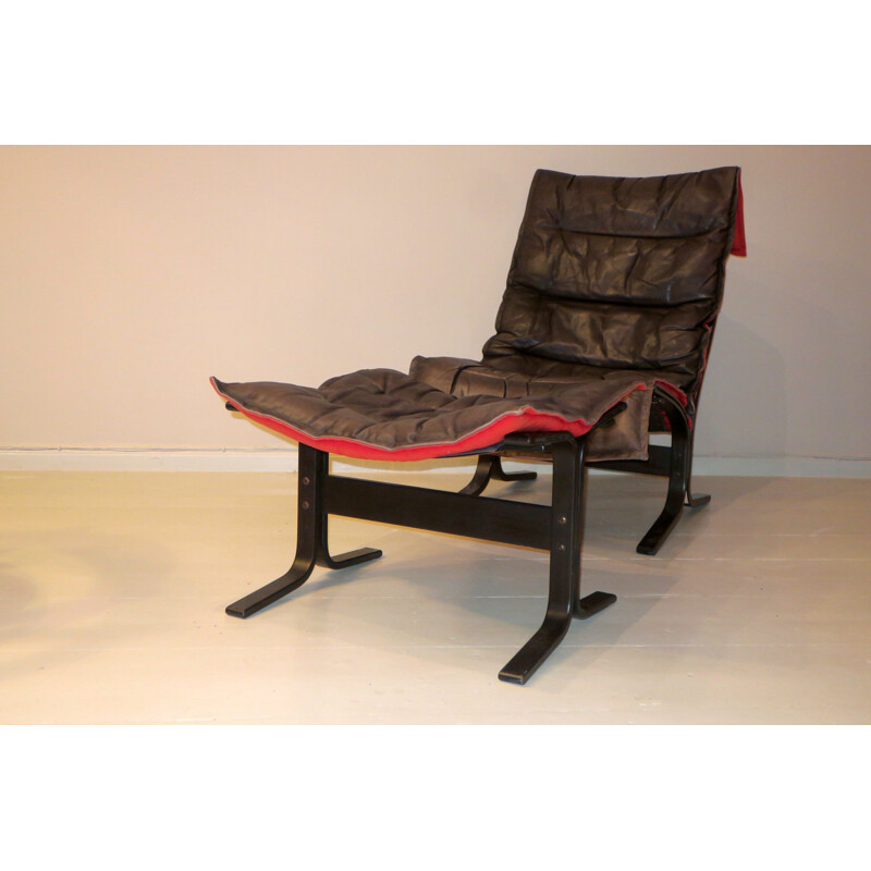 Vintage Siesta fauteuil en voetenbank in zwart leer met rode rug door Ingmar Relling