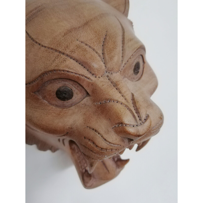 Vintage carved wooden mask representing a roaring tiger