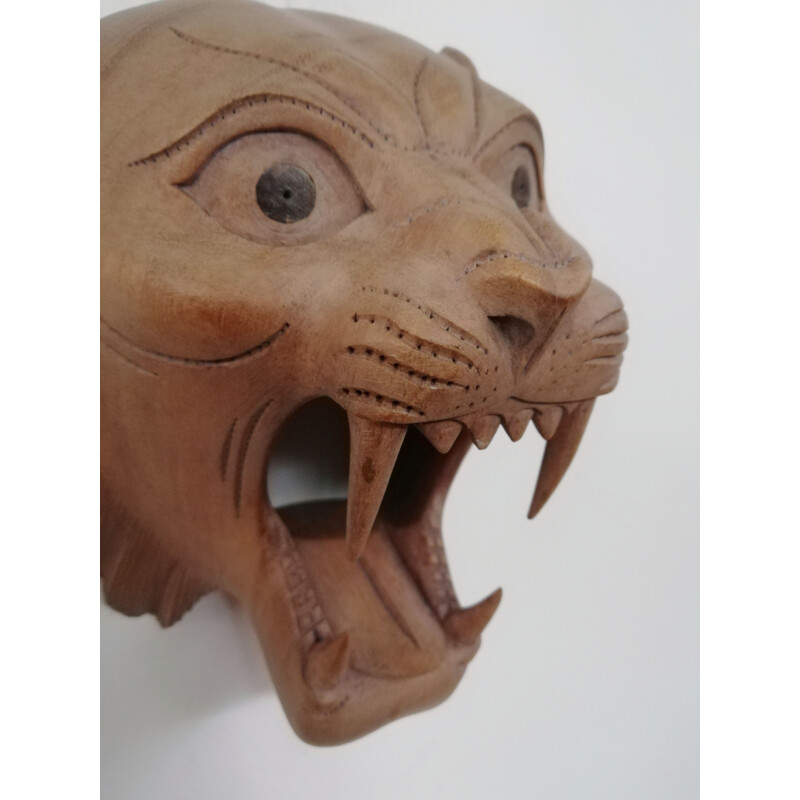 Vintage-Maske aus geschnitztem Holz, die einen brüllenden Tiger darstellt.