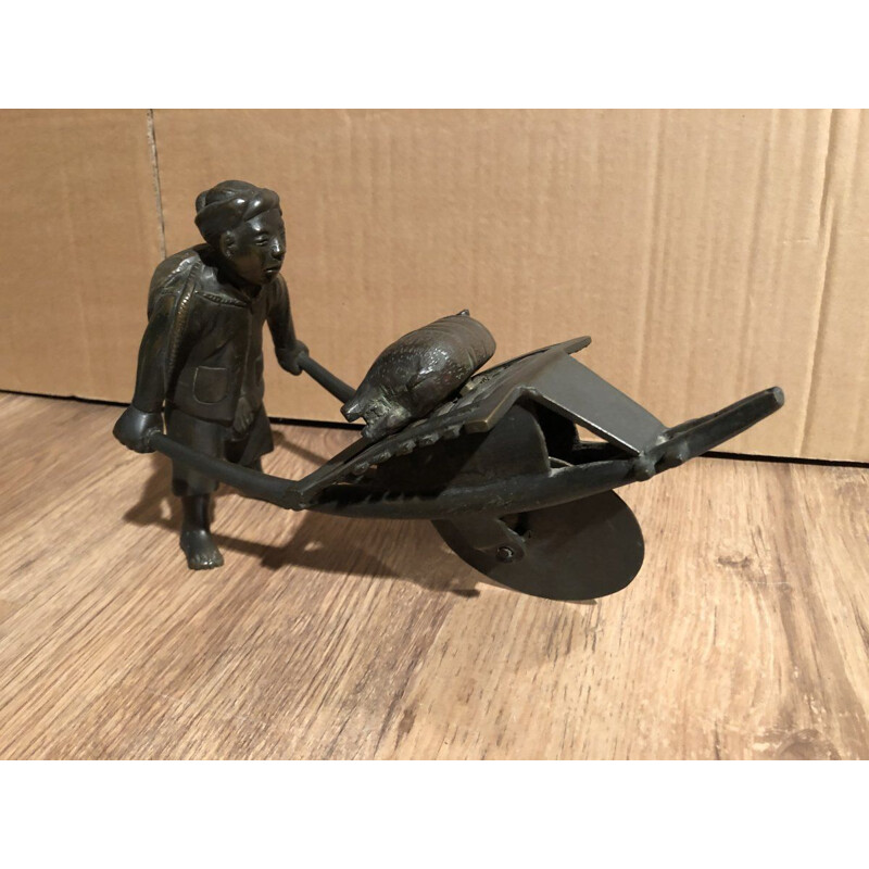 Sculpture of an Asian character pushing a wheelbarrow with her vintage pig, 1900