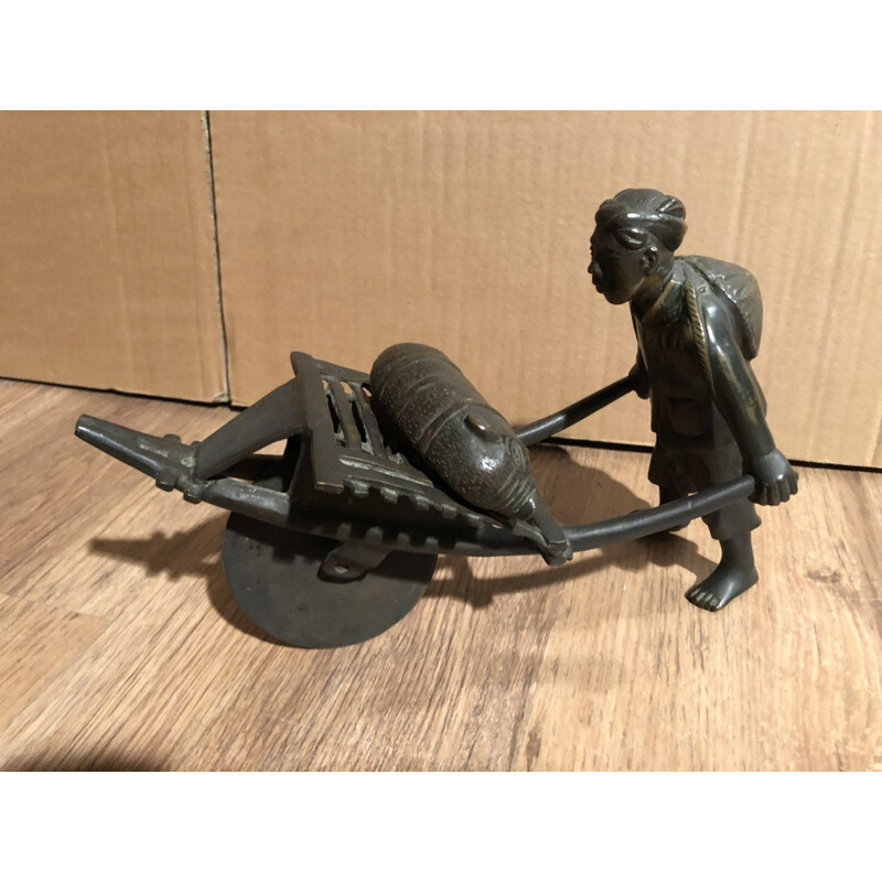 Sculpture of an Asian character pushing a wheelbarrow with her vintage pig, 1900