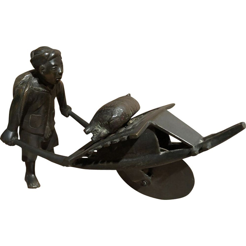 Sculpture of an Asian character pushing a wheelbarrow with her vintage pig, 1900