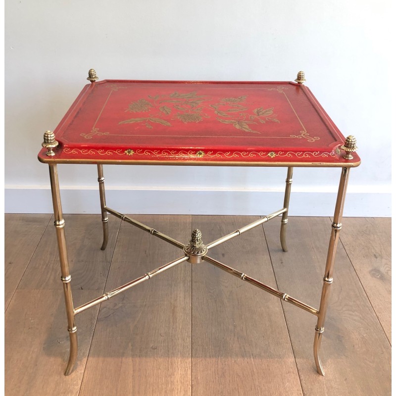 Mesa auxiliar vintage de bronce con tapa lacada en rojo y decoración dorada de Maison Baguès