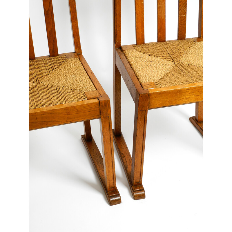 Pareja de sillas vintage de madera de roble con patas deslizantes y asientos de mimbre