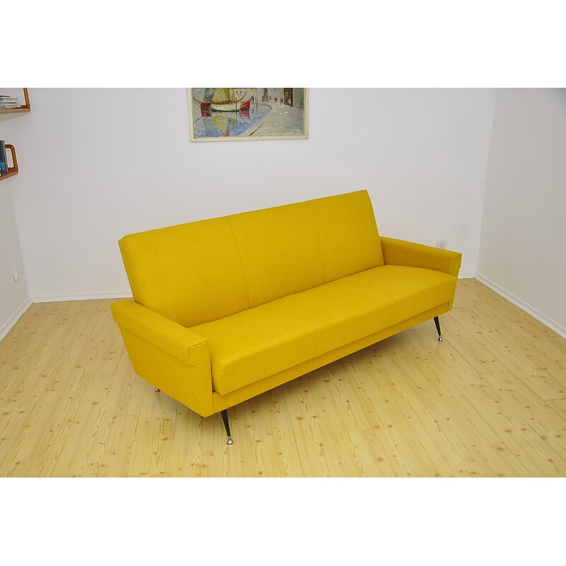 Sofá cama vintage amarillo sobre patas de metal, años 70
