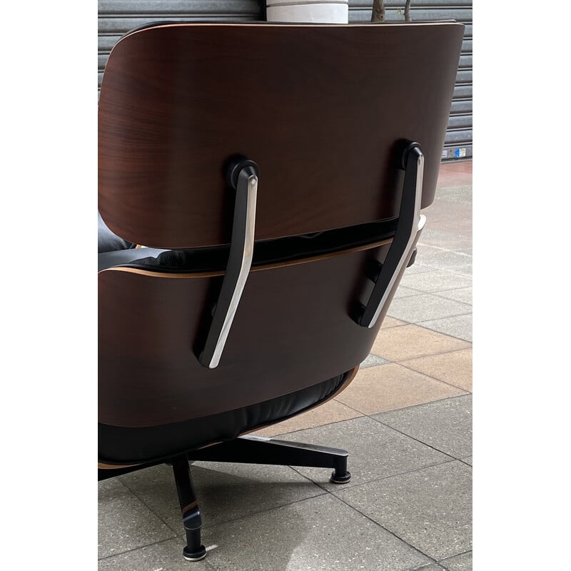 Vintage armchair and ottoman in grained leather and rosewood by Eames for Herman Miller, USA 2009