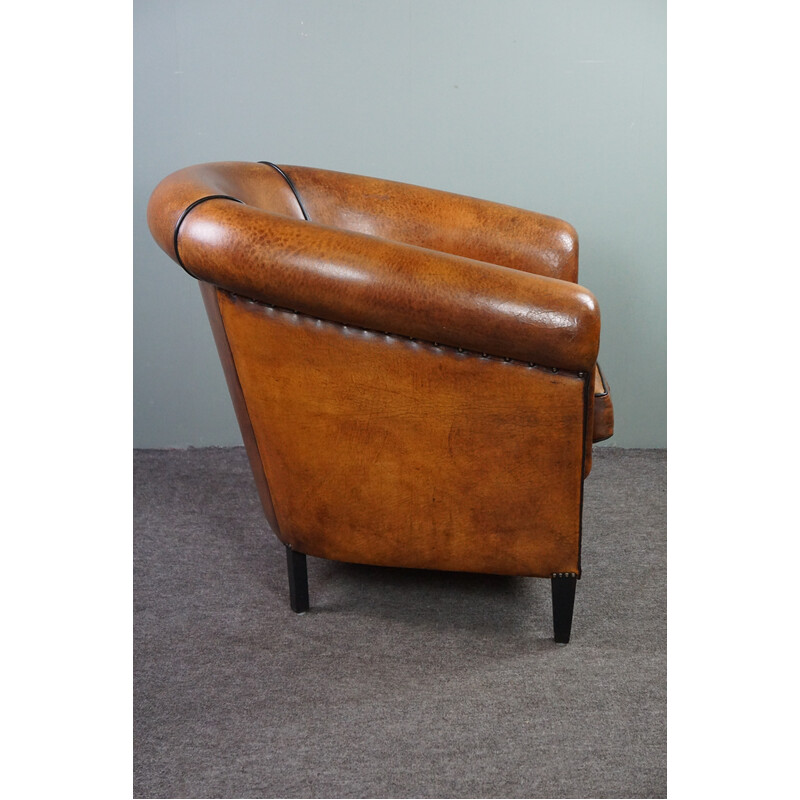 Vintage club chair in sheepskin with decorative studs