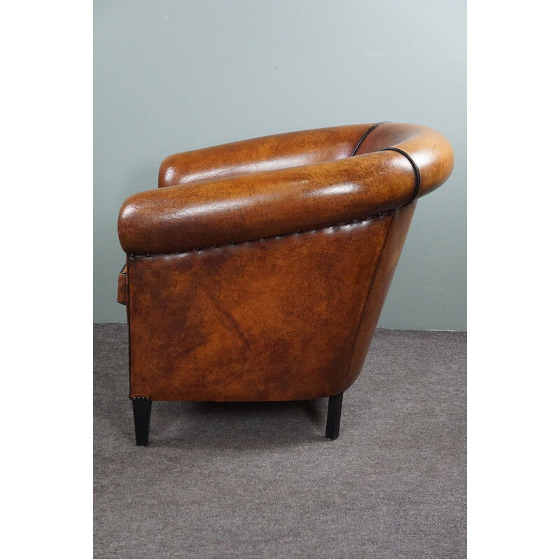 Vintage club chair in sheepskin with decorative studs