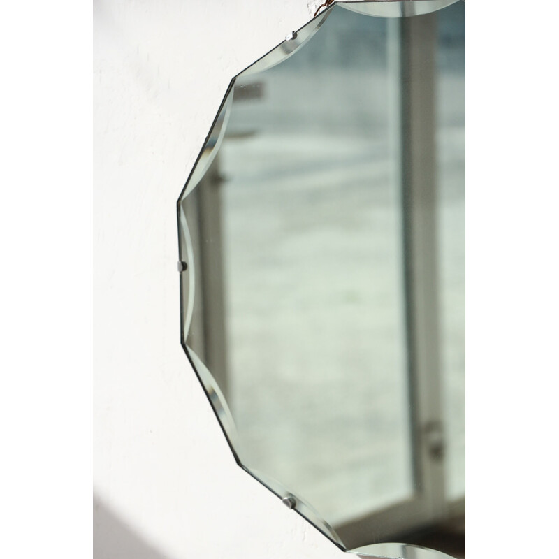 Vintage round beveled mirror on wooden background, 1950