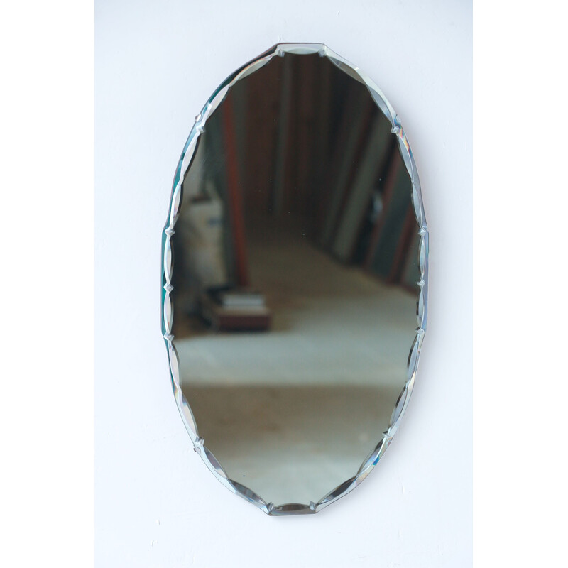 Vintage oval beveled mirror on wooden background, 1950