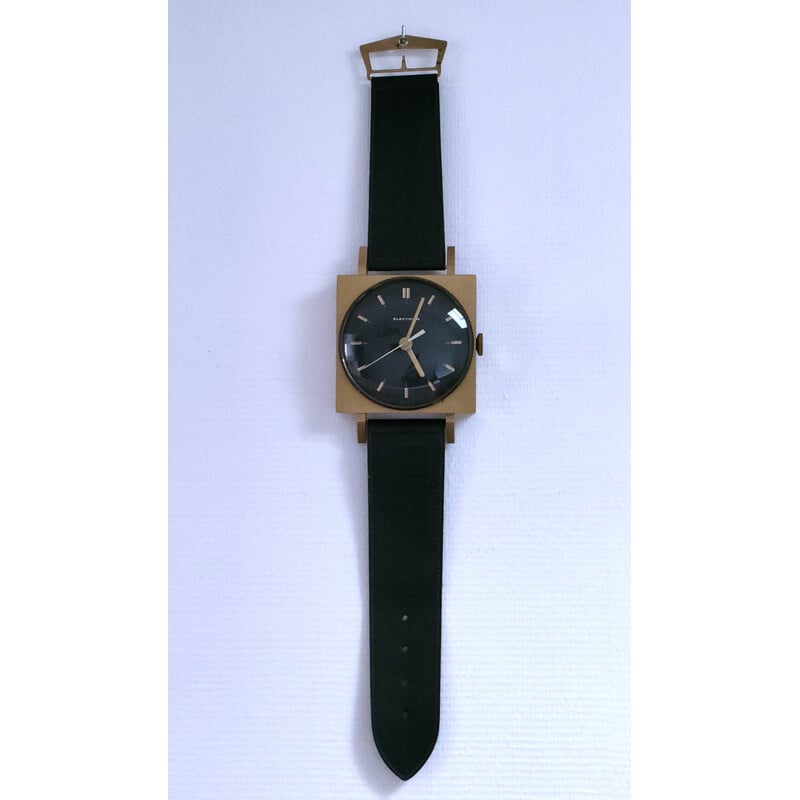 Vintage wandklok in de vorm van een horloge met zwarte imitatieleren band, 1970