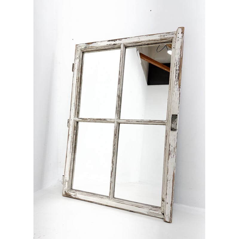 Ein altes Holzfenster, das in einen Spiegel verwandelt wurde