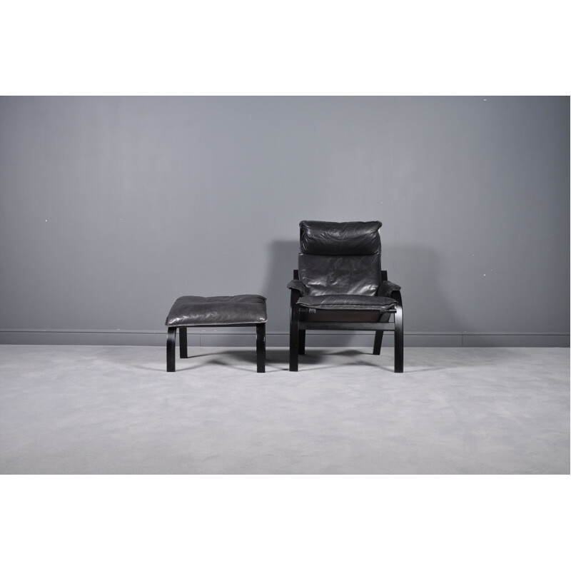 Vintage danish reclining armchair and ottoman in black leather 1960