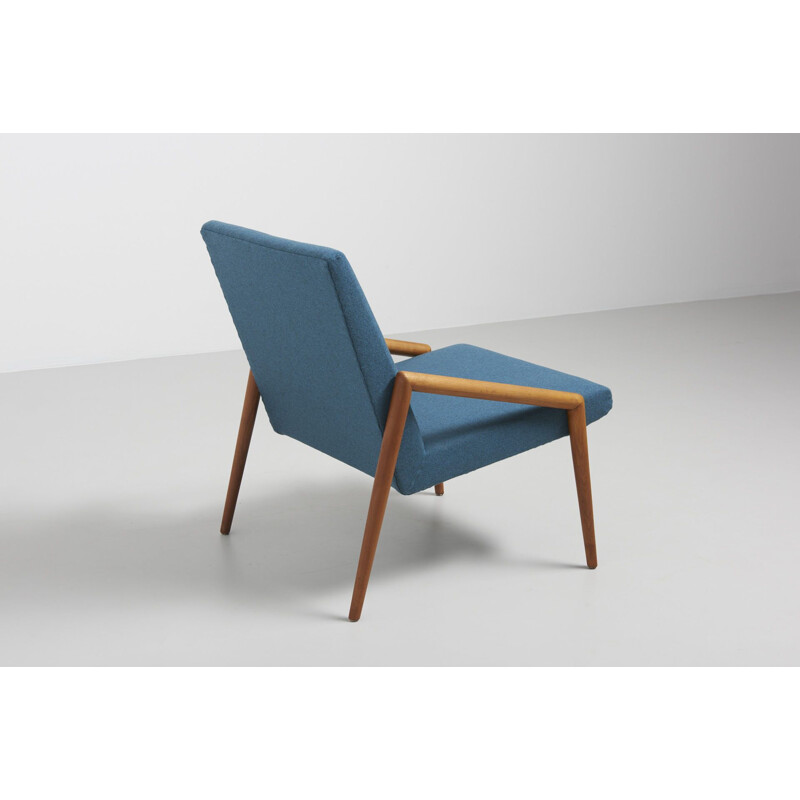 Vintage easy chair with rond teak armrest in blue wool fabric