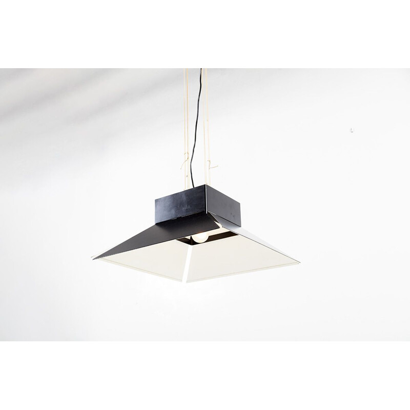 Vintage hanglamp in een zwart geëmailleerde metalen kap hangend aan een zwarte plafondlamp in hetzelfde materiaal