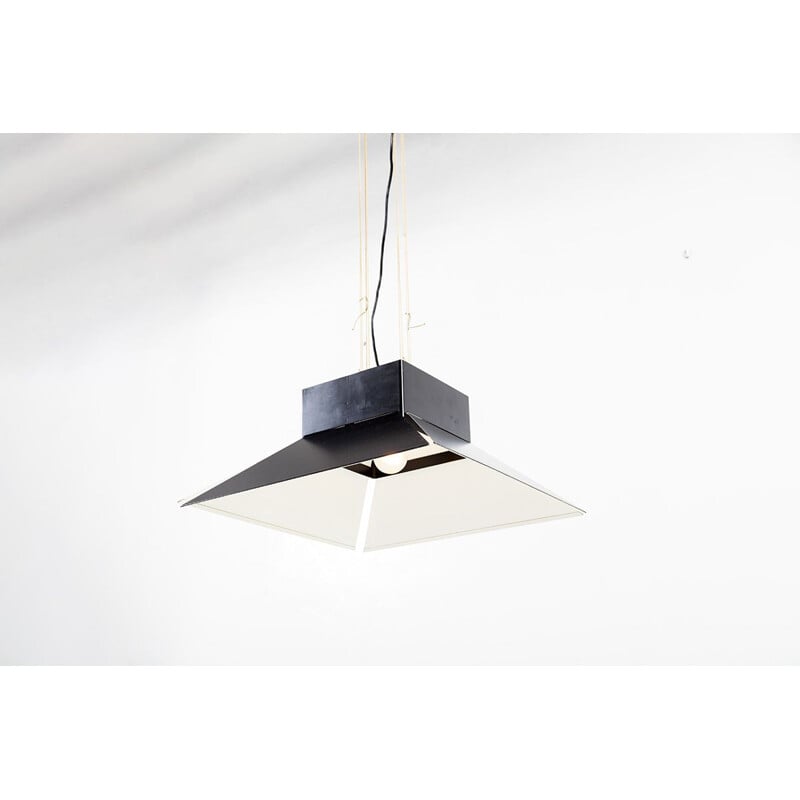 Vintage suspension a shade of black enamel metal that hangs on a black ceiling light in the same material
