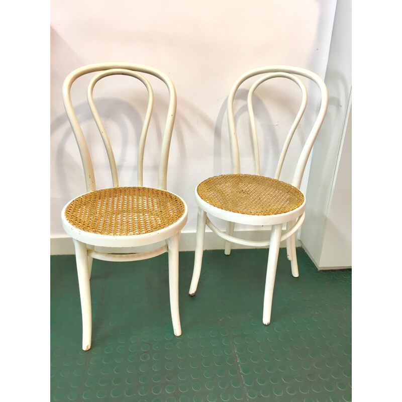 Pair of white bistro chairs with rattan seating