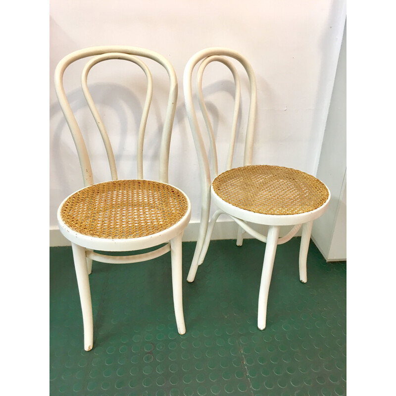 Pair of white bistro chairs with rattan seating