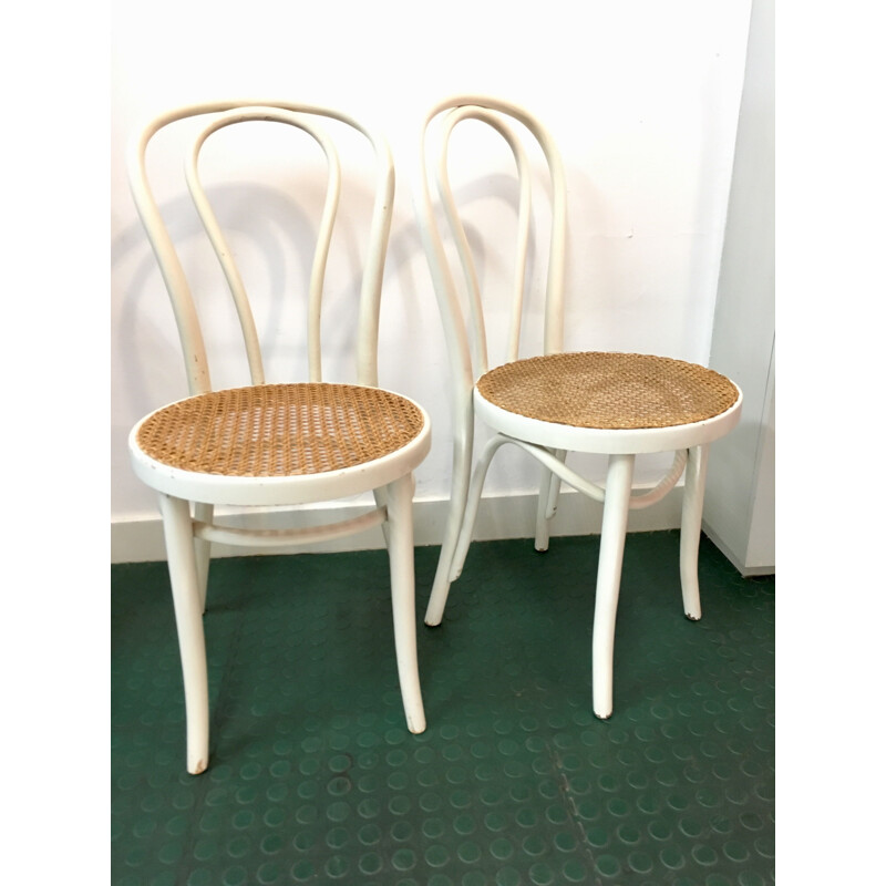 Pair of white bistro chairs with rattan seating