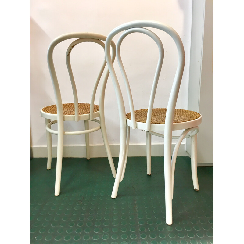 Pair of white bistro chairs with rattan seating