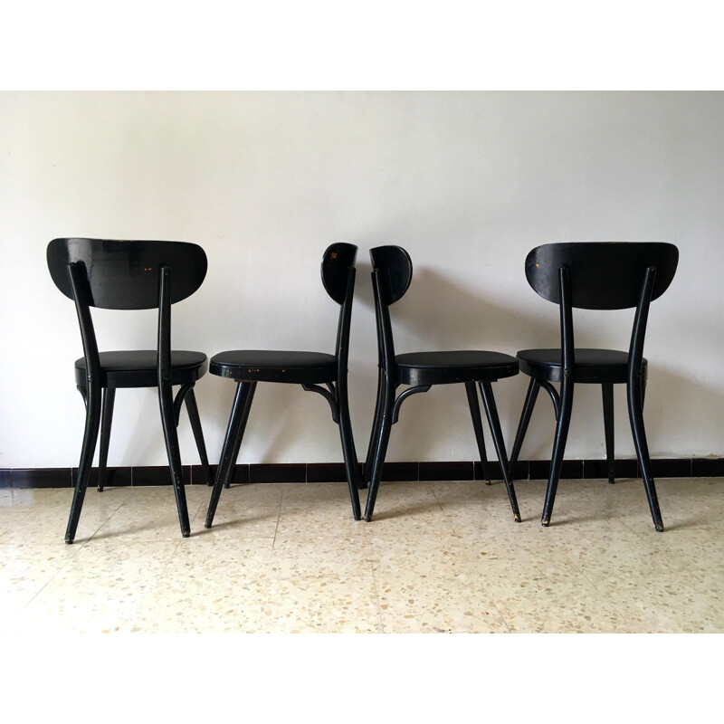 Suite de 4 chaises vintage Baumann en skaï noir et bois 1950